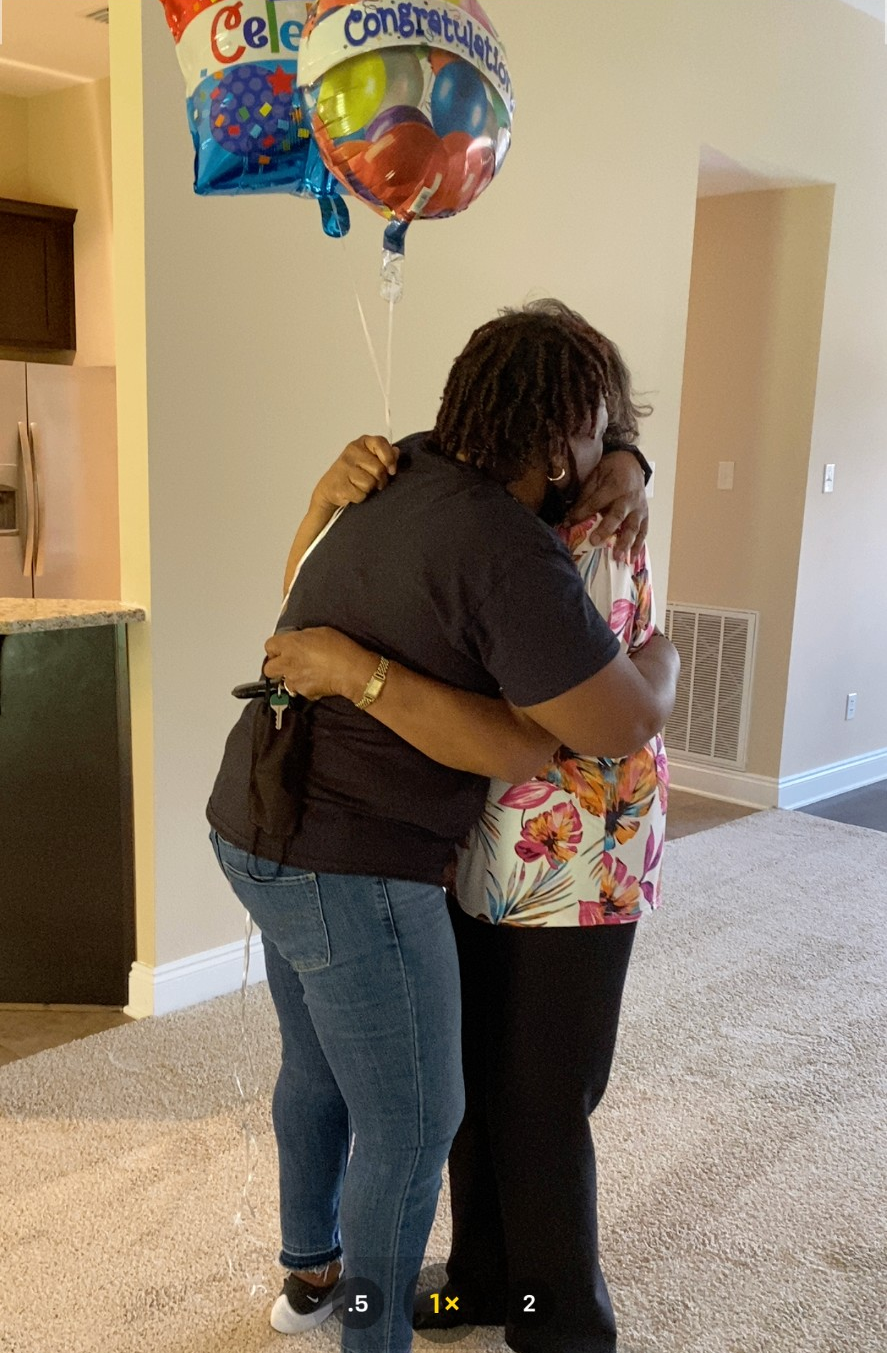 Ms. Sanders and Tracee sharing a celebratory hug with Congratulations balloons